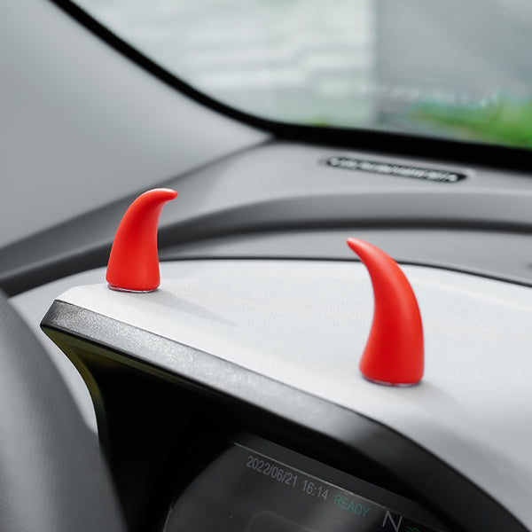 Cornes décoratives rouges positionnées devant le compteur d'une voiture