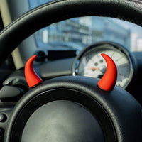 Cornes rouges décoratives installées sur volant de voiture pour un look amusant