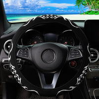 Couvre volant noir tribal à motifs flammes argentées vu de face installé dans une voiture