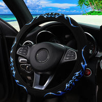 Couvre volant tribal noir décoré de flammes bleues scintillantes installé sur un volant de voiture, idéal pour un intérieur sportif et élégant