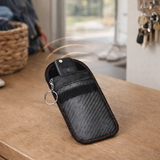 Pochette de protection pour clé de voiture posée dans une entrée de maison pour sécuriser le signal